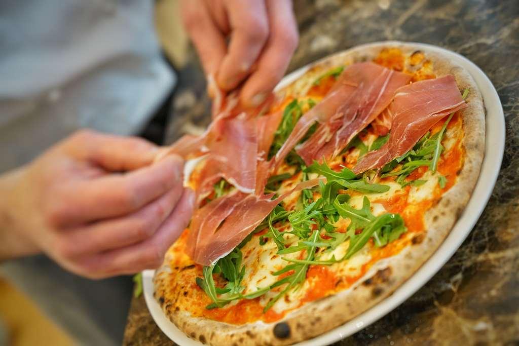 Vila Vita Rosenpark Marburg Eksteriør billede Pizza being topped with prosciutto